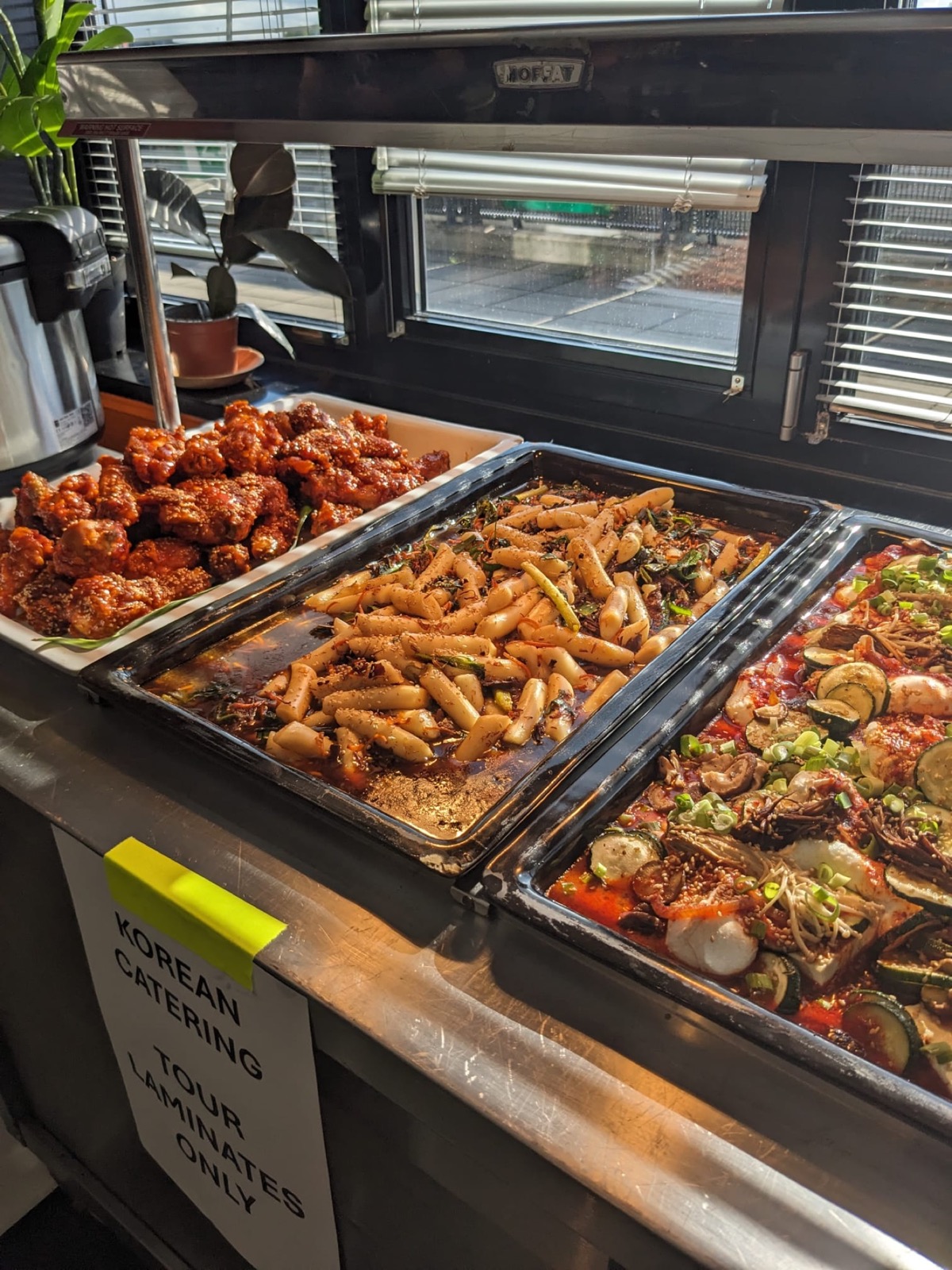 Korean chicken, rice cakes and vegetables arranged for touring buffet service