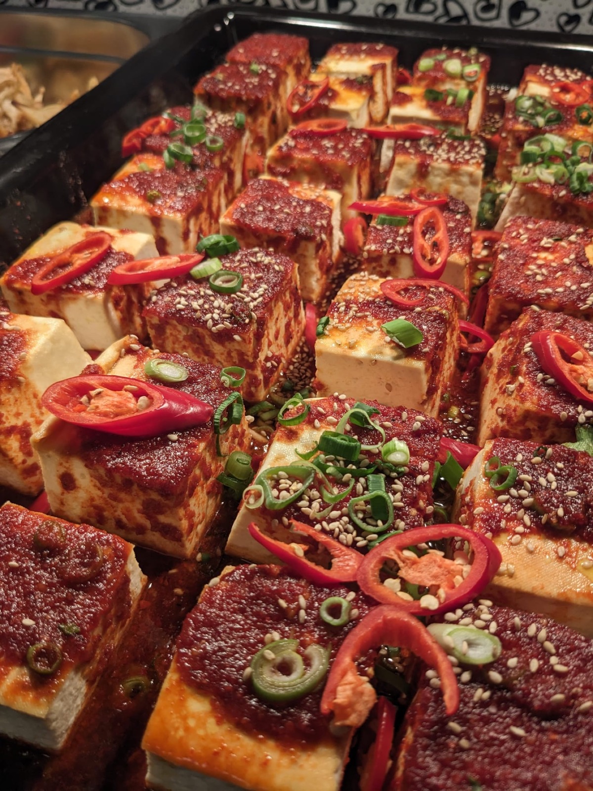 Spicy tofu portions garnished for high-volume Korean meal service